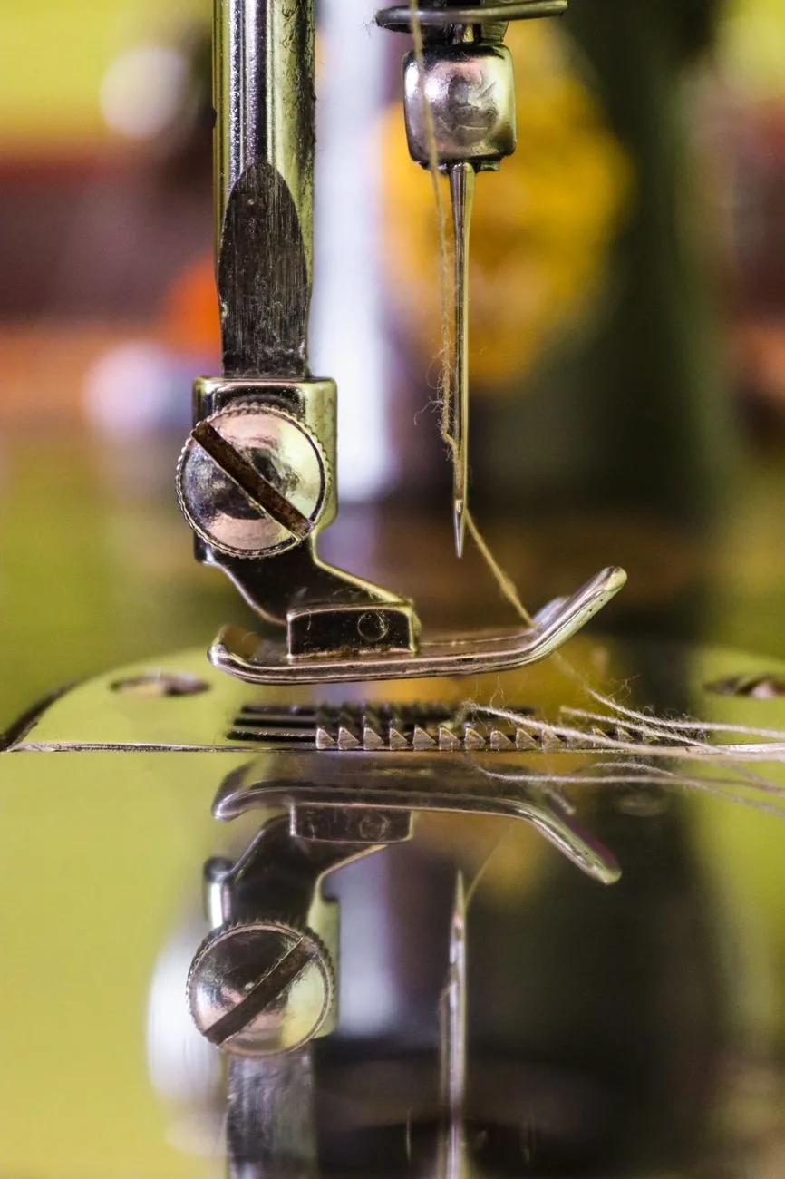 Macro detail of an industrial sewing machine — the kind Krishna Sales has supplied since 2004